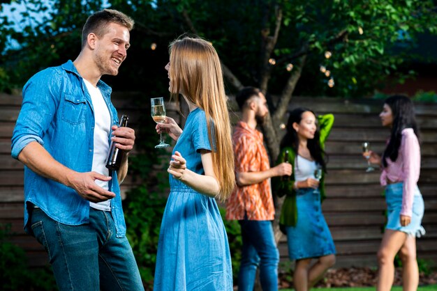 Vooraanzicht vrienden met drankjes dansen