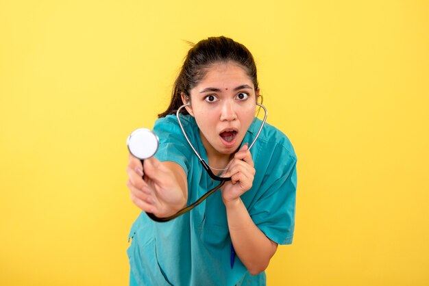 Vooraanzicht vroeg zich af jonge vrouwelijke arts met een stethoscoop op gele achtergrond
