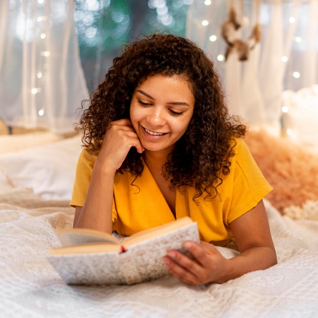 Gratis foto vooraanzicht vrouw binnen lezen