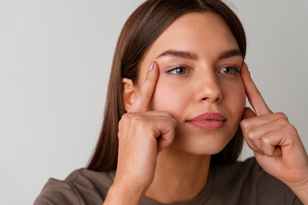 Vooraanzicht vrouw die gezichtsyoga beoefent