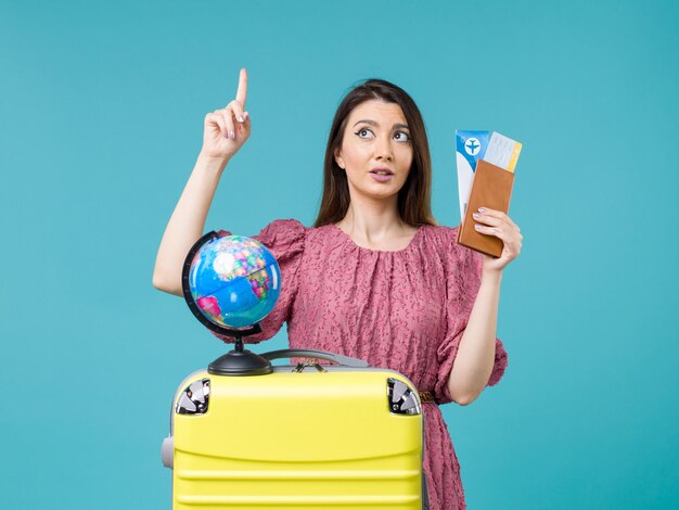 Vooraanzicht vrouw in vakantie bedrijf vliegtickets op de blauwe achtergrond zee vakantie vrouw reis reis reis