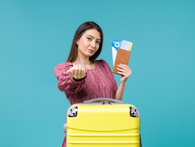 Vooraanzicht vrouw in vakantie met haar portemonnee en kaartjes iemand bellen op blauwe achtergrond reis reis vrouw zomer zee vakantie