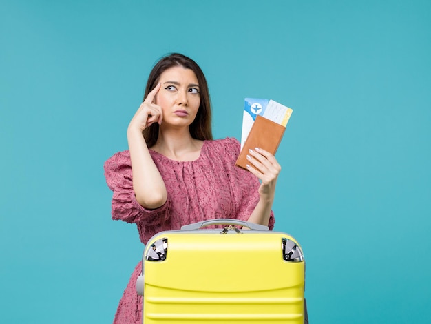 Vooraanzicht vrouw in vakantie met haar portemonnee en kaartjes op blauwe achtergrond reis vakantie reis vrouw zomer zee