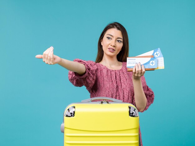 Vooraanzicht vrouw in vakantie met haar portemonnee en kaartjes op de blauwe achtergrond reis vrouw zomer reis zee vakantie