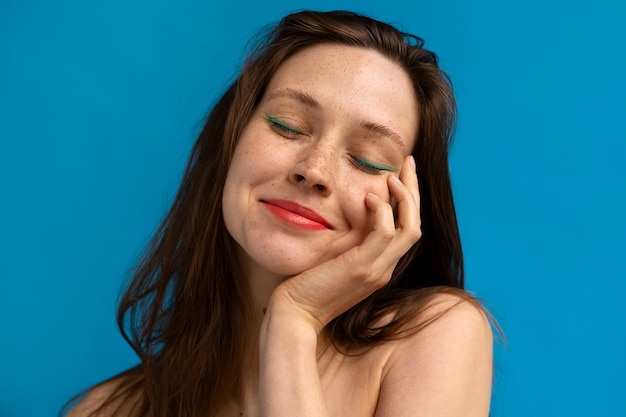 Gratis foto vooraanzicht vrouw poseren met blauwe achtergrond