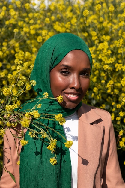 Gratis foto vooraanzicht vrouw poseren met mooie bloemen