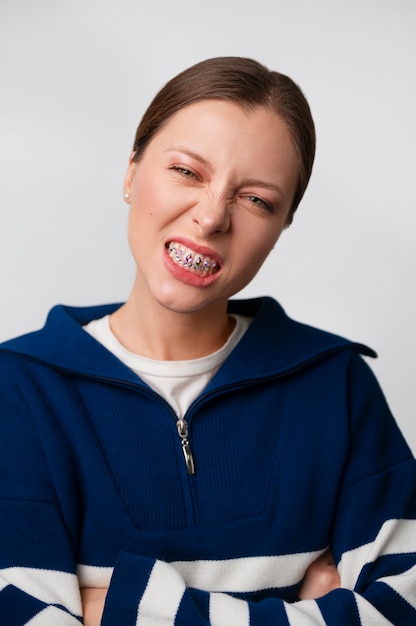 Gratis foto vooraanzicht vrouw poseren met tandheelkundige edelstenen