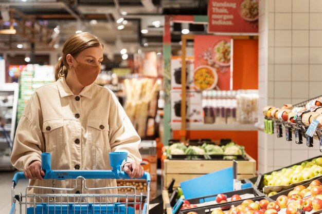 Vooraanzicht vrouw winkelen met gezichtsmasker