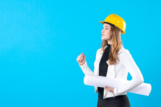 Gratis foto vooraanzicht vrouwelijke architect in gele helm met plan op blauw