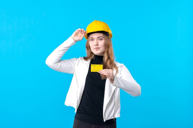 Vooraanzicht vrouwelijke architect met bankkaart op blauw