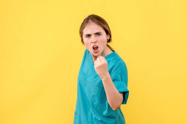 Vooraanzicht vrouwelijke arts bedreigend op gele achtergrond ziekenhuis medic gezondheid emotie