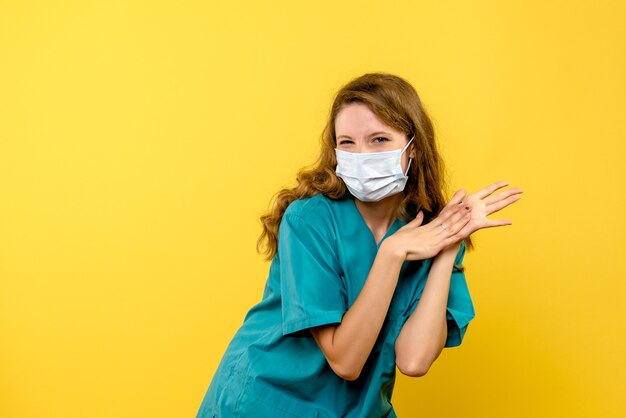 Vooraanzicht vrouwelijke arts in masker op gele ruimte