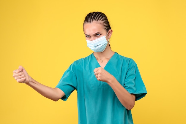 Vooraanzicht vrouwelijke arts in medisch overhemd en masker boos, gezondheidsverpleegster ziekenhuisvirus covid-19 pandemische kleur