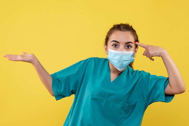 Vooraanzicht vrouwelijke arts in medisch overhemd en masker, virus pandemie uniform gezondheid kleur covid-19 coronavirus
