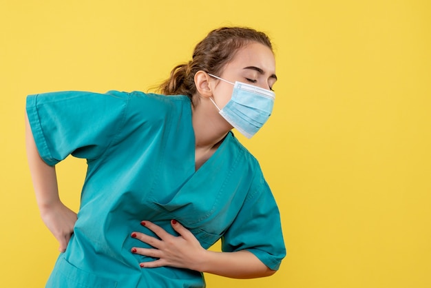 Vooraanzicht vrouwelijke arts in medisch overhemd en masker, virus pandemie uniform kleur covid-19 gezondheid coronavirus