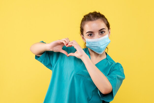 Vooraanzicht vrouwelijke arts in medisch overhemd en steriel masker, pandemisch gezondheid uniform covid-19-virus