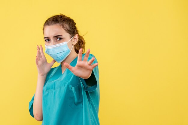 Vooraanzicht vrouwelijke arts in medisch overhemd en steriel masker, ziekte coronavirus uniform virus covid pandemie