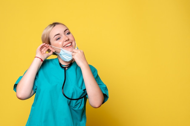 Vooraanzicht vrouwelijke arts in medisch overhemd met haar masker, verpleegster medic covid-19 ziekenhuis gezondheid pandemie