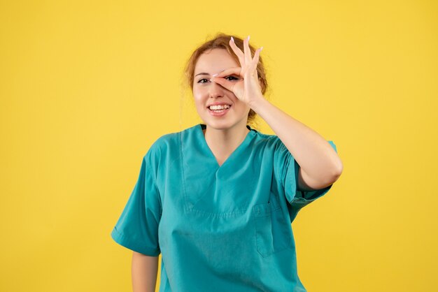 Vooraanzicht vrouwelijke arts in medisch overhemd, verpleegsterskleur covid-19 gezondheidsmedicijn
