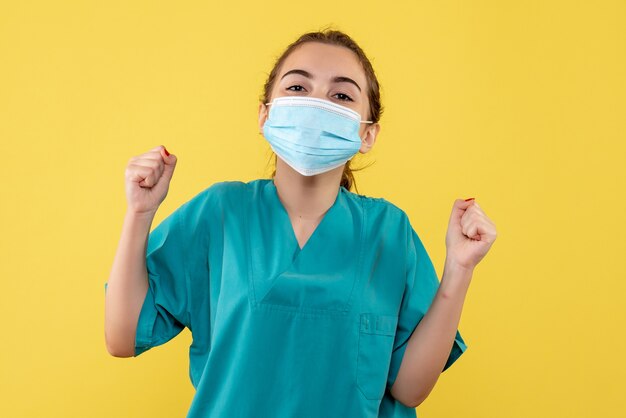 Vooraanzicht vrouwelijke arts in medisch shirt en masker verheugend, virus pandemie uniform covid-19 gezondheid coronavirus