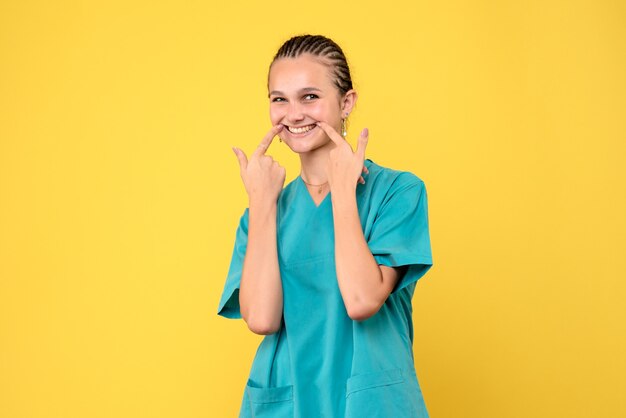 Vooraanzicht vrouwelijke arts in medisch shirt, gezondheid emotie verpleegster covid-19 virus kleur ziekenhuis