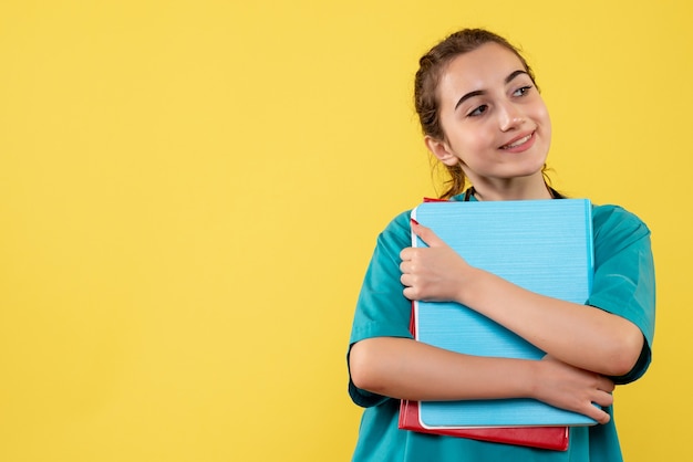 Vooraanzicht vrouwelijke arts in medisch shirt met verschillende notities, kleur virus gezondheid emoties covid-19 pandemie uniform