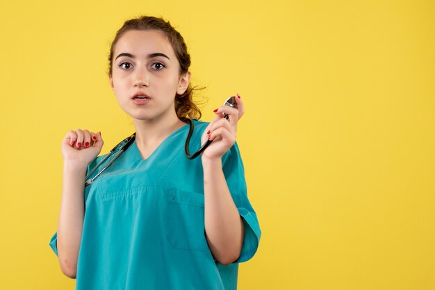 Vooraanzicht vrouwelijke arts in medisch shirt, uniforme kleur emotie virus covid-19 gezondheid