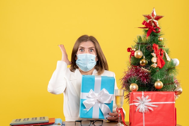 Vooraanzicht vrouwelijke arts in steriel masker met cadeautjes