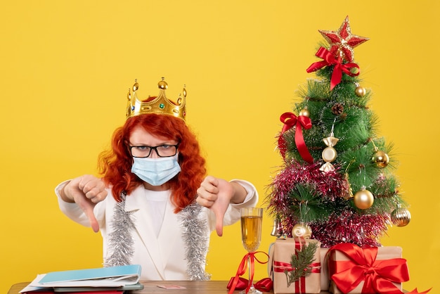 Vooraanzicht vrouwelijke arts in steriel masker rond kerstcadeautjes
