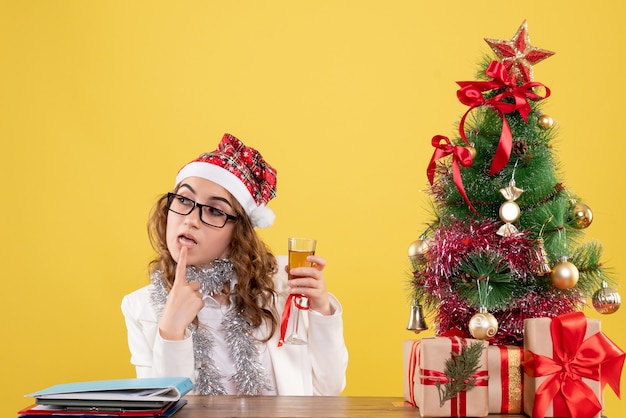 Vooraanzicht vrouwelijke arts Kerstmis vieren met een glas champagne