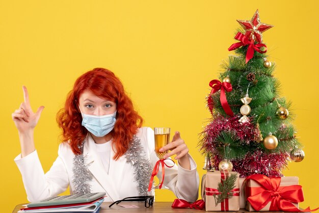 Vooraanzicht vrouwelijke arts Kerstmis vieren met een glas champagne