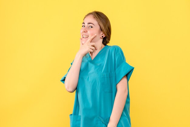 Vooraanzicht vrouwelijke arts lachend op gele achtergrond ziekenhuis medic gezondheid emotie