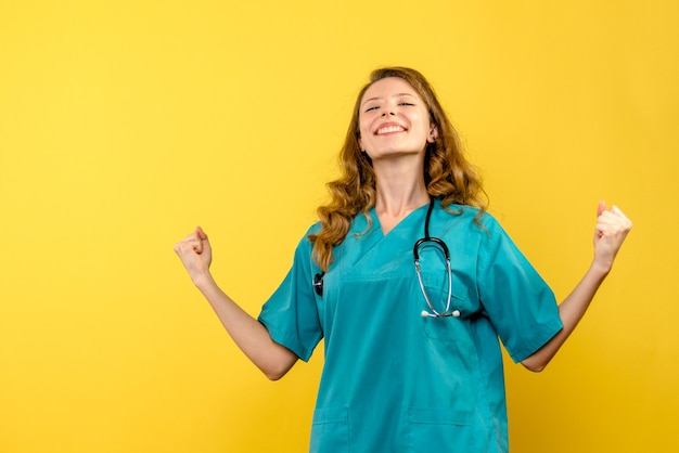 Vooraanzicht vrouwelijke arts lachend op gele ruimte