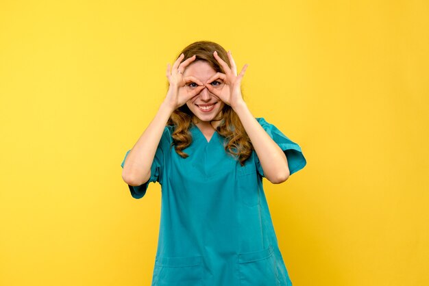 Vooraanzicht vrouwelijke arts lachend op gele ruimte