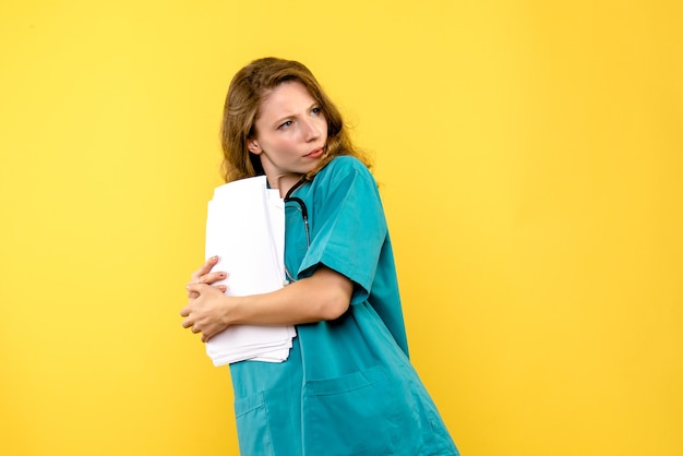 Vooraanzicht vrouwelijke arts met bestanden op gele ruimte