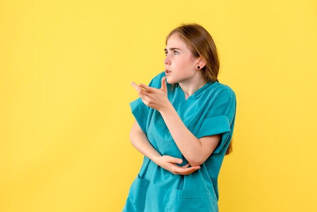 Vooraanzicht vrouwelijke arts op gele achtergrond medic emoties ziekenhuis gezondheid virus