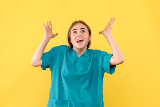 Vooraanzicht vrouwelijke arts opgewonden op gele achtergrond gezondheid medicus emotie ziekenhuis