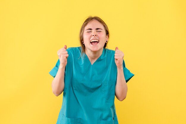 Vooraanzicht vrouwelijke arts vreugde op gele achtergrond emoties ziekenhuis medic gezondheid