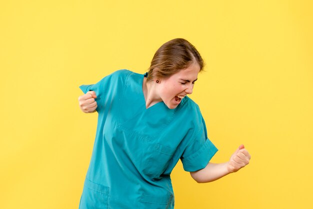 Vooraanzicht vrouwelijke arts vreugde op gele achtergrond medic gezondheid ziekenhuis emotie