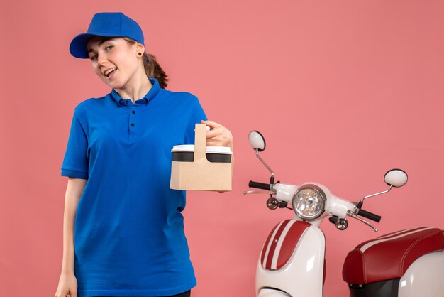 Vooraanzicht vrouwelijke koerier met bezorgkoffie op roze vloer werk bezorgdienst werknemer vrouw fiets uniform baan