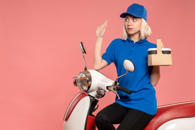 Vooraanzicht vrouwelijke koerier met koffiekopjes op de roze bezorgdienst werk kleur werknemer uniform baan