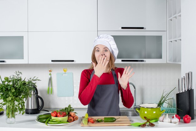 Vooraanzicht vrouwelijke kok in schort hand op haar mond zetten