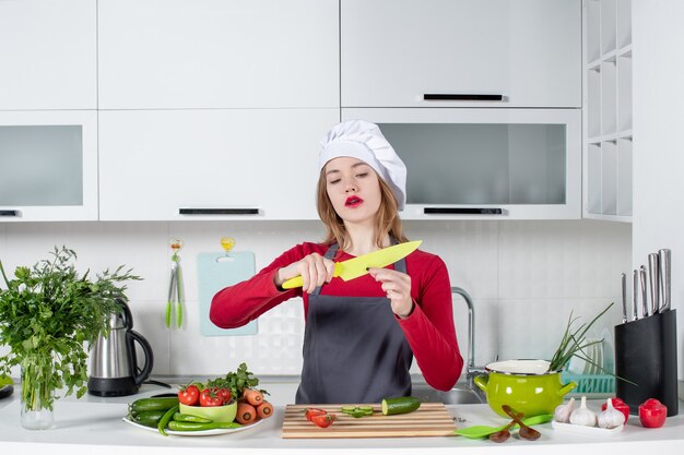 Vooraanzicht vrouwelijke kok in schort met geel mes