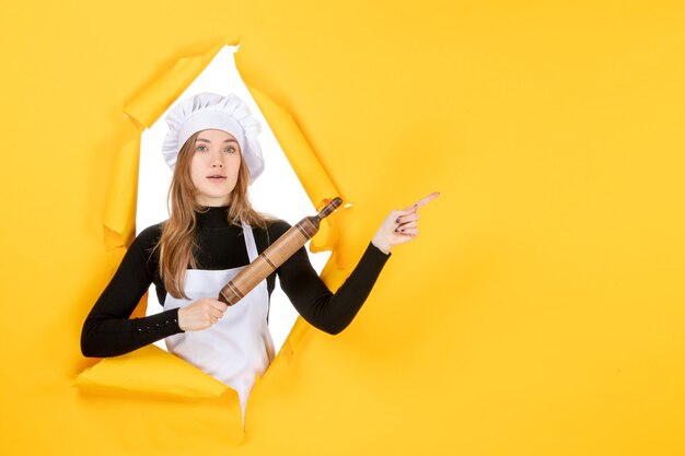 Vooraanzicht vrouwelijke kok met deegroller op gele kleur keuken baan keuken eten zon foto emoties