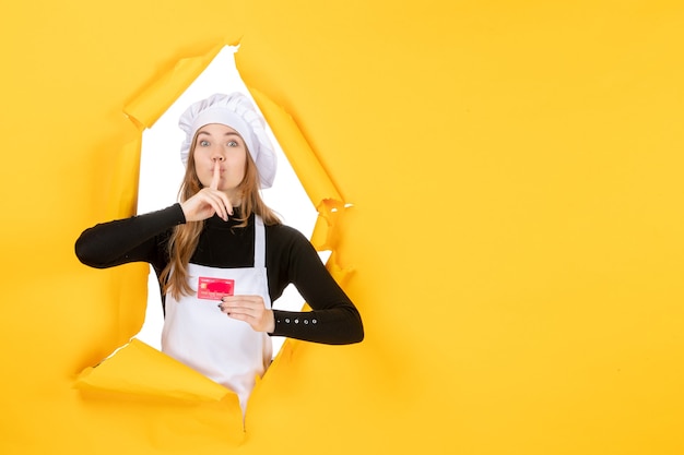 Vooraanzicht vrouwelijke kok met rode bankkaart op gele baan foto emotie keuken kleur geld keuken