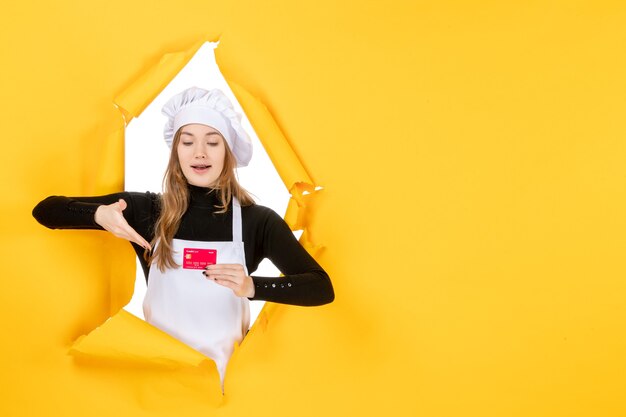 Vooraanzicht vrouwelijke kok met rode bankkaart op gele baan foto emotie voedsel keuken kleur