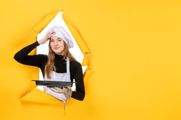 Vooraanzicht vrouwelijke kok met zwarte pan op gele emotie zon voedsel foto baan keuken kleur