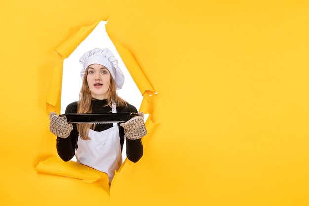 Vooraanzicht vrouwelijke kok met zwarte pan op gele zon tijd voedsel foto keuken emotie keuken kleur