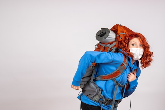 Gratis foto vooraanzicht vrouwelijke toerist die in bergreis in masker met rugzak gaat