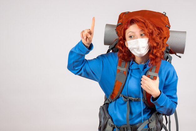 Vooraanzicht vrouwelijke toerist in masker met haar rugzak